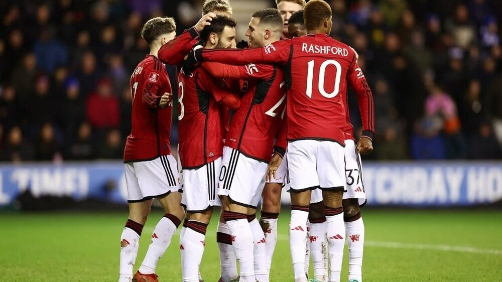 United players celeberating with Bruno Fernandez after he converts 74th penalty against Wigan Athletic