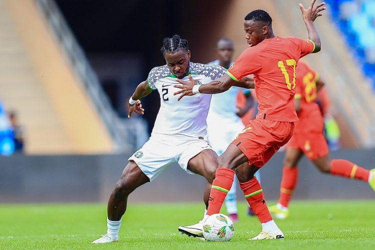 Super Eagles Midfielder Osayi Samuel (left) goes in for a tackle vs Ghana